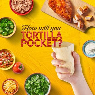 A person holding an empty Old El Paso tortilla pocket over a table full of taco ingredients, with the words 'How will you tortilla pocket?'