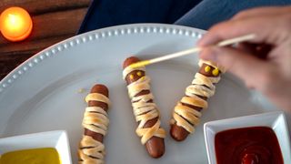 Halloween-themed hot dogs wrapped in dough to look like mummies